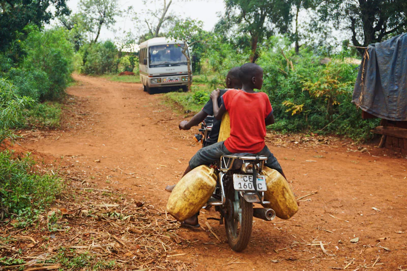 Une moto chargée de sacs sur une piste de terre rouge