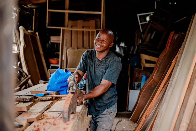 Un menuisier souriant en travaillant le bois