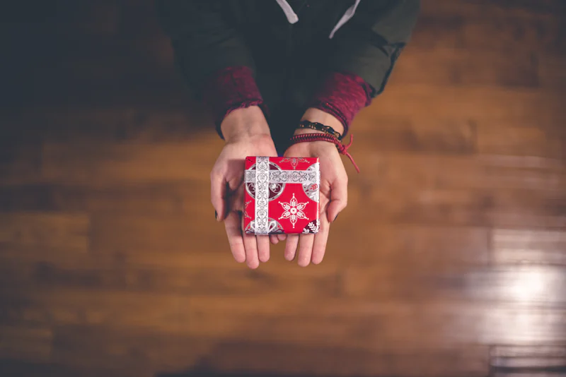 Des mains offrant un petit cadeau emballé